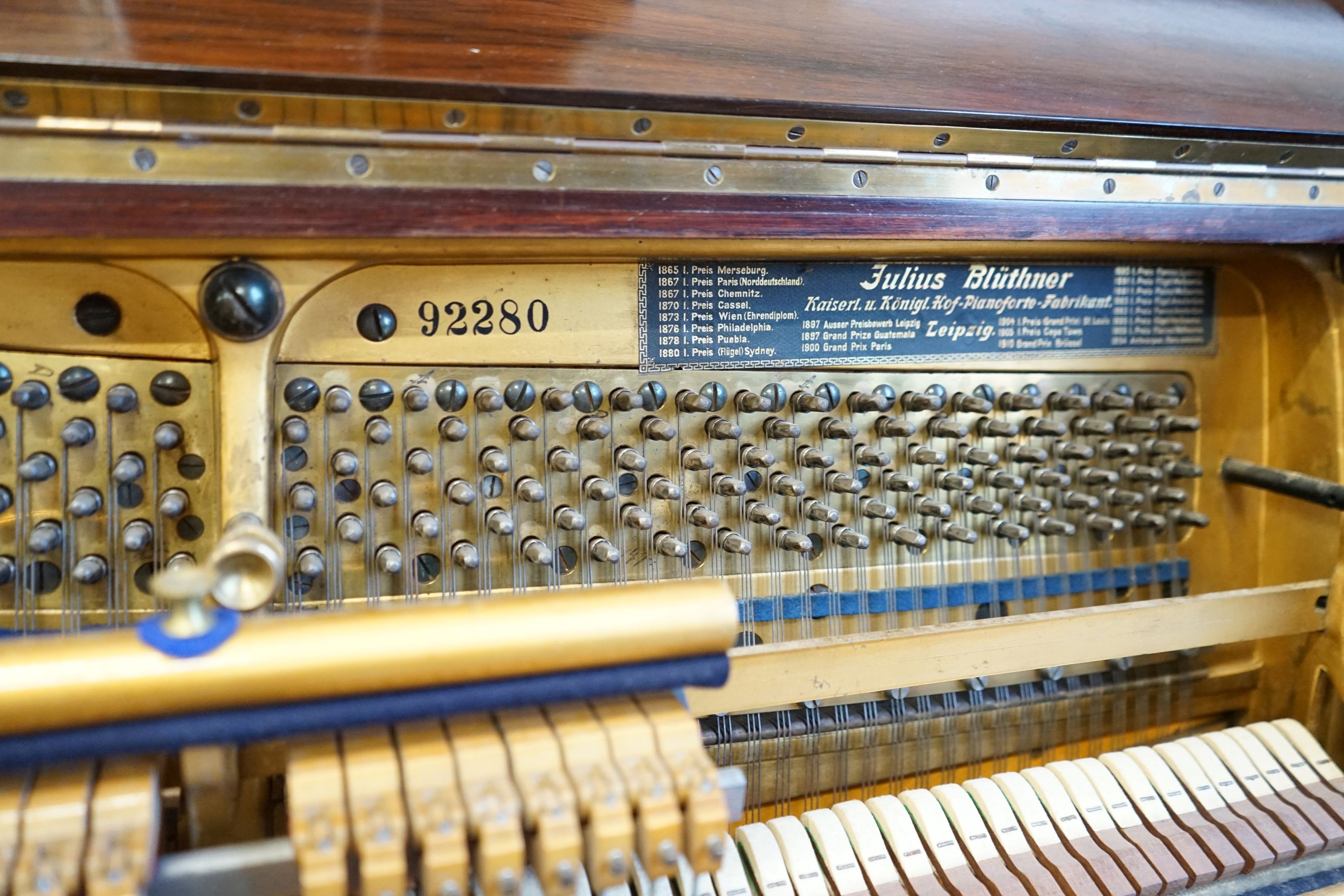 An early 20th century walnut cased Bluthner upright piano, Serial Number 92280